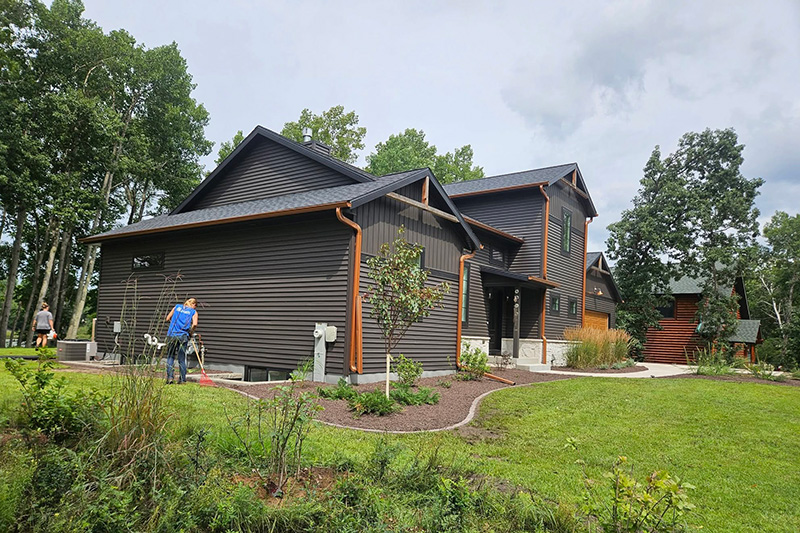 DMC Landscaping crew installing new garden beds and plantings around a residential home in Nekoosa, Wisconsin