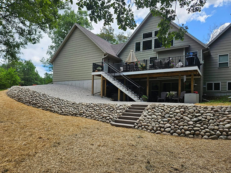 9:06 AMClaude responded: Round boulder retaining wall with built-in steps and a gravel area beneath a raised deck in Nekoosa, WisconsinRound boulder retaining wall with built-in steps and a gravel area beneath a raised deck in Nekoosa, Wisconsin