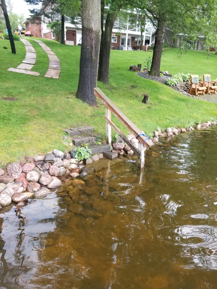 9:08 AMClaude responded: Deteriorating lakefront steps and rock shoreline before landscaping renovation with a stepping stone path visible in the yard aboveDeteriorating lakefront steps and rock shoreline before landscaping renovation with a stepping stone path visible in the yard above
